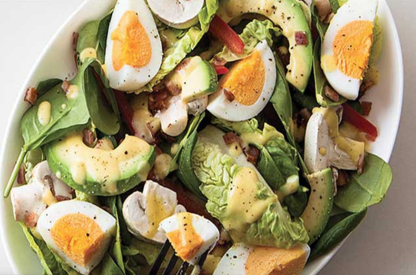 Ensalada de espinacas, aguacate y huevo con agujas en aceite.